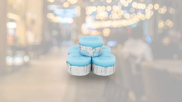 lima buah Bahan bakar padat KAEN berwarna biru ditumpuk dengan background gambar restoran