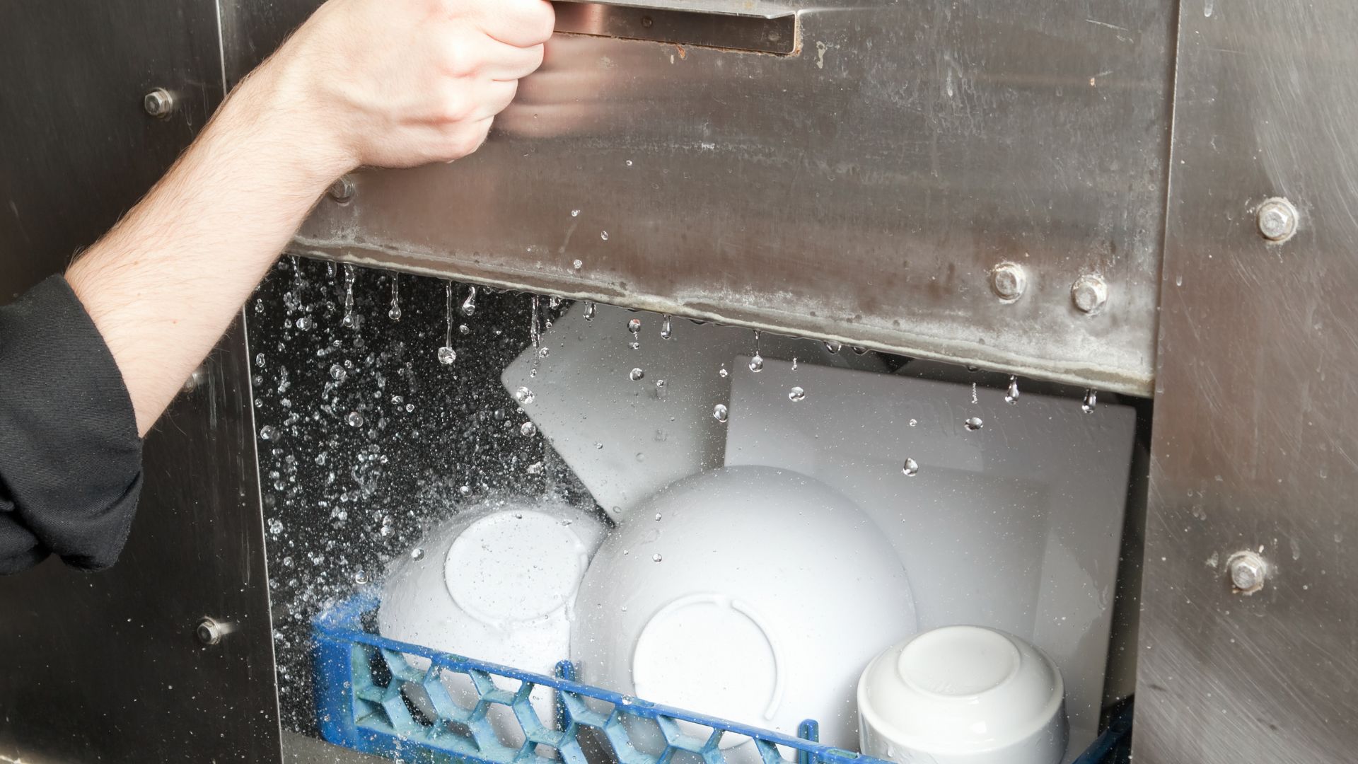 dishwasher machine sedang beroperasi untuk membersihkan alat makan restroran